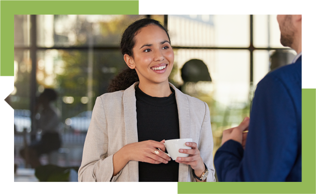 A woman and man engaged in casual conversation at the office.